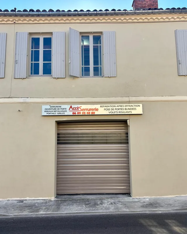 Façade de l’atelier AccèSerrurerie, avec son enseigne et son rideau métallique